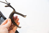 Vintage African gazelle figurine held in hand, showing its scale and dark, aged patina.