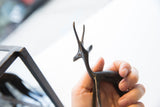 Vintage African gazelle figure held in hand to show its delicate scale.