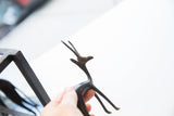 A hand holding the slender vintage African gazelle collectible with a dark patina.
