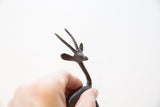 Finely detailed head of a vintage gazelle figurine with ridged, tapering horns.