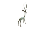 Slender vintage African gazelle sculpture with long horns and green patina.