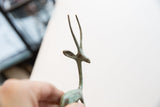 Vintage African gazelle figurine head with green patina and textured horns.
