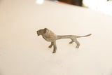 Side profile of a small vintage African lion with an oxidized metal finish.