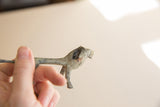 Side view of a vintage African lion showing its rough, oxidized patina.