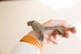 Vintage African lion figure held in hand, showing its oxidized patina and scale.