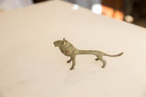 Side profile of the vintage African lion highlighting its slender, oxidized form.