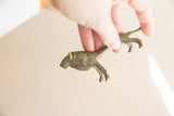Oxidized vintage African lion held in hand to demonstrate its small, collectible size.