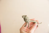Side view of the vintage oxidized African lion held in hand for scale.