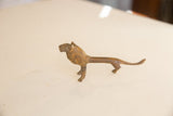 Elongated profile of the vintage African lion showing its textured, oxidized metal patina.