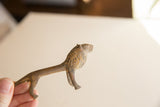 A hand holding the vintage African lion to show its slender profile and scale.