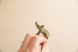 Vintage African bronze boar figurine shown in profile with a textured patina.
