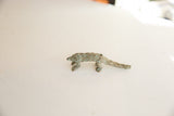 Vintage pangolin sculpture in profile view highlighting its scaled texture and patina.