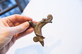 Vintage African pendant held in hand to show its scale and textured patina.