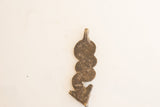 The unadorned back of a vintage African pendant, revealing its weathered texture.