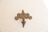 Aged patina and hand-worked texture on the reverse side of the African pendant.
