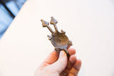 Angled view of the vintage African pendant showing its concave form and texture.