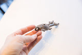 Vintage African pendant shown in-hand to display scale and textured metal patina.
