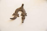 Vintage African pendant with cross-hatched texture and carved stylized animal heads.
