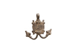 Vintage African pendant with a central spiral motif and aged dark metal patina.