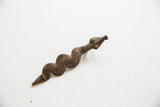 Side profile of the vintage African pendant, highlighting its carved serpentine shape and dark patina.
