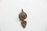 The flat, unadorned back of the vintage African pendant showing a coarse, aged texture.
