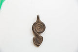 Back view of the vintage African pendant showing its rustic metal texture.