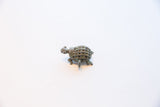 Side profile of the vintage African turtle pendant showing its form and oxidized patina.