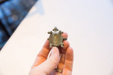 Back of vintage turtle pendant showing linear shell details and aged patina.