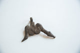 Angled view of the vintage bronze snake pendant's dark, textured surface patina.