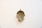 Aged bronze texture on the hollow back of the vintage African face pendant.