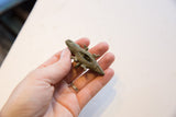 Vintage African bronze crocodile pendant held in hand, showing its size and texture.