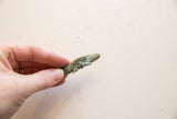 Vintage bronze crocodile pendant held in hand to demonstrate scale and textured patina.