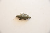 Aged bronze patina and etched patterns on a vintage African crocodile pendant.