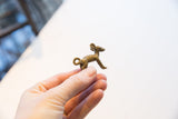Vintage African impala pendant held to show its small scale and detailed, aged finish.