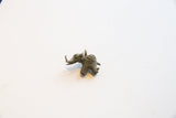 Profile view of a vintage African bronze elephant pendant with a textured, oxidized patina.