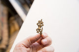 Vintage African bronze pendant held in hand to show its small size and cast texture.