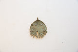 Back view of the African bronze pendant showing its concave form and aged patina.