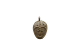 Vintage African bronze face pendant with a weathered patina and stylized facial features.