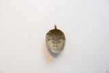 The hollowed-out back of the vintage African bronze pendant showing its aged patina.