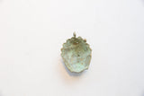 Reverse view of the vintage African bronze pendant showing its concave shape and aged patina.