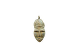 Vintage African bronze face pendant with stylized features and a weathered, textured patina.