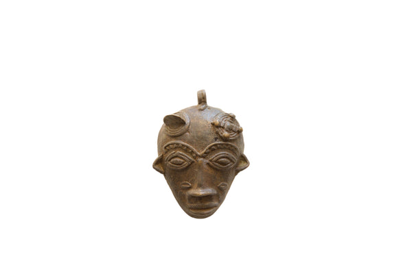Vintage African bronze face pendant with stylized features and a weathered, aged patina.