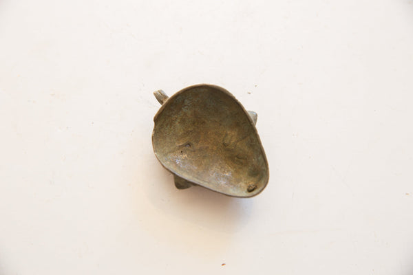 Back view of the vintage African bronze pendant showing the hollowed interior and aged patina.