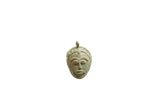 Vintage African bronze face pendant with stylized features and a weathered green patina.