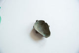 Angled view of the bronze pendant's concave interior showing aged patina.