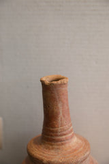 Close-up of the rustic flared opening and textured neck of the antique pottery vase.