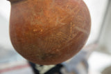 Close-up of the aged, earthy texture on the antique red slip ware pottery.