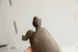 Angled profile of a vintage tortoise sculpture showing its textured, hand-formed head.
