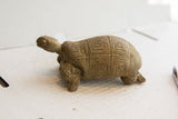 Side profile of a vintage African tortoise sculpture with a hand-carved geometric shell.