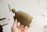 Vintage African tortoise sculpture held in hand, showing the carved geometric shell pattern.
